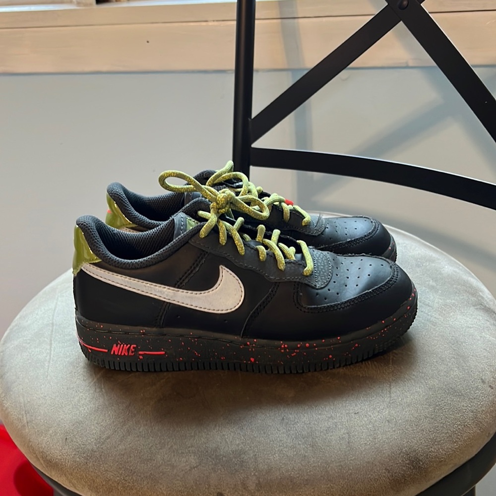 Boys Nike black Air Force ones with green laces.
